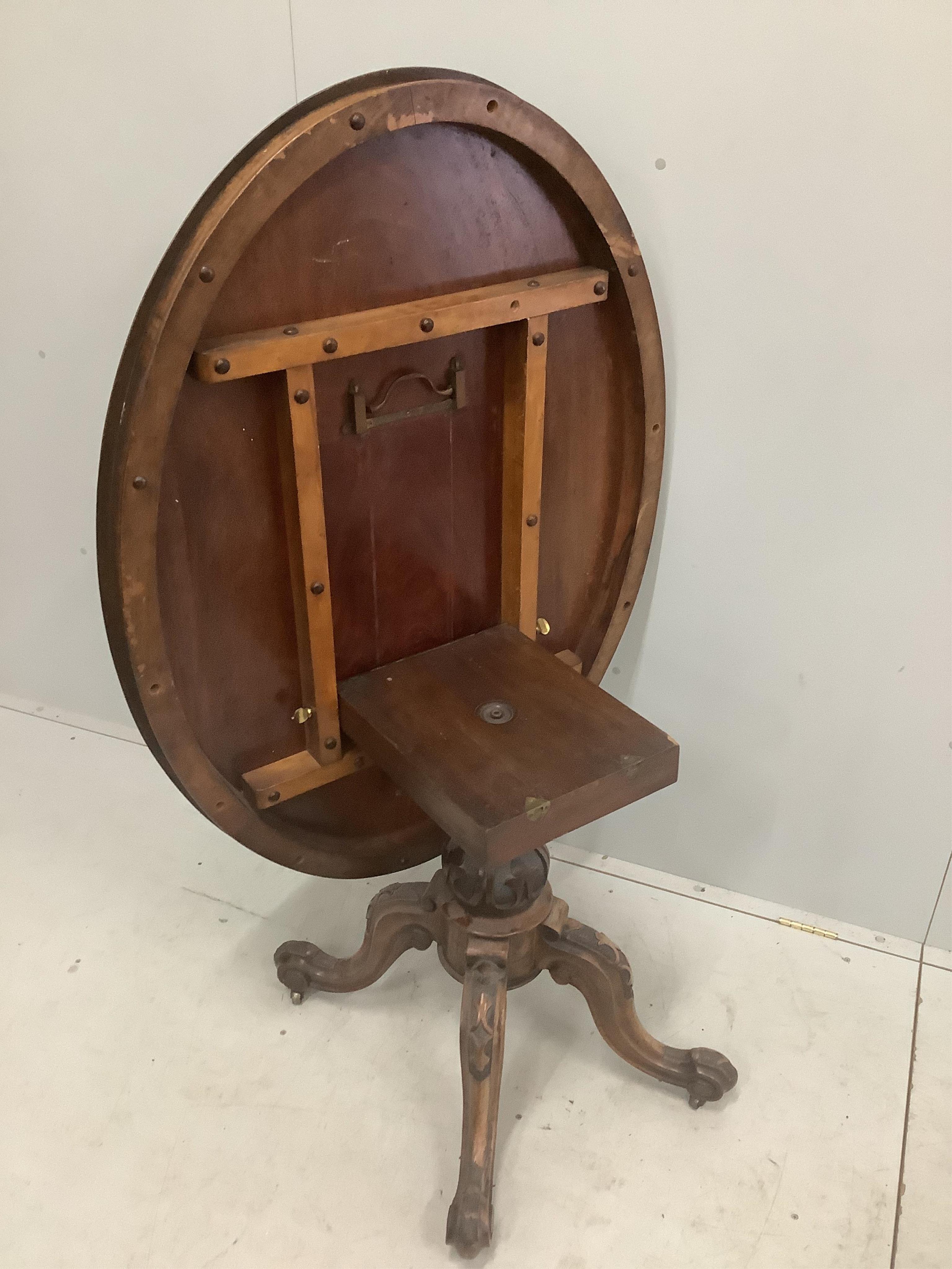 A Victorian carved walnut oval tilt top breakfast table, 120 x 92cm, height 72cm. Condition - fair